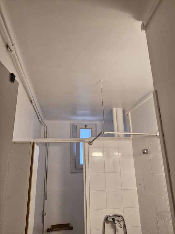 Plafond de salle de bain repeint en blanc au-dessus de la douche