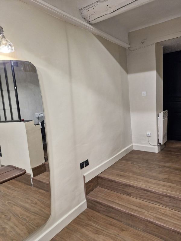 Salon de coiffure : mur beige fini, grand miroir, marches et sol effet bois